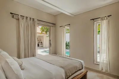 a bedroom with a bed and two windows at 3 Bathroom Bali villa in Kerobokan
