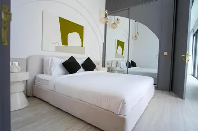 a bedroom with a large white bed and a mirror at Brand New Luxury5 Stars Designer By Villa-Amare Villa 1 in Kerobokan