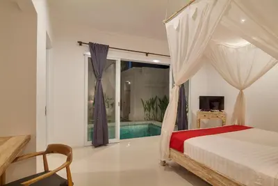 a bedroom with a canopy bed and a swimming pool at 3BR Villa3 Oberoi Seminyak,18Min walk to the beach in Seminyak