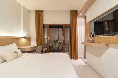 a bedroom with a large white bed in a room at The Hita Uluwatu in Jimbaran