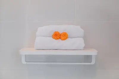 two towels with orange pompoms sitting on a shelf at 2BR Villa Central Seminyak,50 m walk to the beach in Seminyak