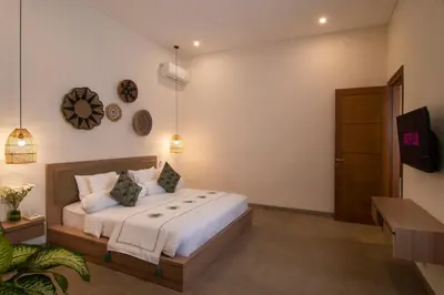 a bedroom with a bed and a tv on a wall at LaBumbak 01 - 2BR Villa Escape in Umalas with Private Pool in Canggu