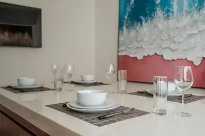 a table with plates and wine glasses on a counter at Queen Villa D1 by Betterplace in Seminyak