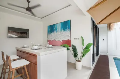 a living room with a bar and a swimming pool at Queen Villa D1 by Betterplace in Seminyak