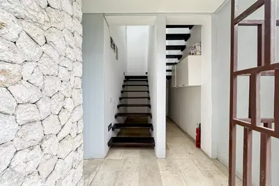 a staircase in a house with a stone wall at Garden Leaf Villa - 2 Bedroom Pool Villa with Minimum Stay 2 Nights in Nusa Dua