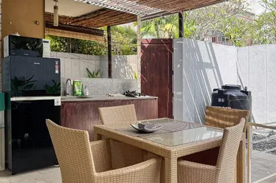 a table and chairs in a kitchen with a counter at Garden Leaf Villa - 2 Bedroom Pool Villa with Minimum Stay 2 Nights in Nusa Dua