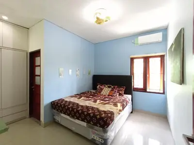 a bedroom with a bed with blue walls and a window at Designer Alex Villa Jimbaran Bali in Jimbaran