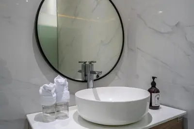 a bathroom with a sink and a large mirror at Villa Shinta by JB Villas in Seminyak