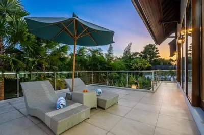 a patio with two chairs and an umbrella at Villa Shinta by JB Villas in Seminyak