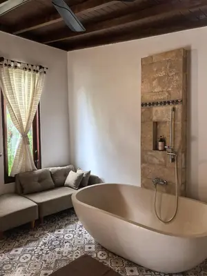 a bathroom with a tub and a couch at Villa Veyla Seminyak 10 mins walk to beach in Seminyak