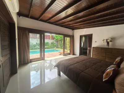 a bedroom with a bed and a swimming pool at Villa Veyla Seminyak 10 mins walk to beach in Seminyak