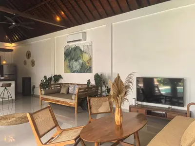 a living room with a table and chairs and a tv at Villa Veyla Seminyak 10 mins walk to beach in Seminyak