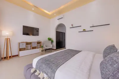 a white bedroom with a bed and a tv at Villa Fénix Brand New 1BR Villa in Umalas, Bali in Kerobokan