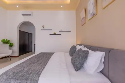 a bedroom with a white bed with pillows on it at Villa Fénix Brand New 1BR Villa in Umalas, Bali in Kerobokan