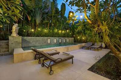 a patio with a bench and a pool with trees at Walk, Best of Berawa, 5bd villa, 2min from Finns in Canggu