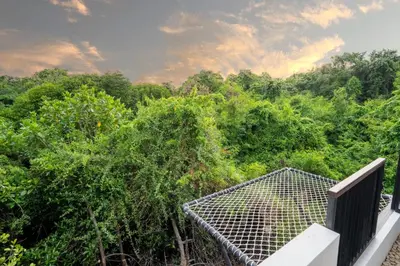 a viewing deck with trees in the background at Jimbaran Breeze Villa By Island Escape in Jimbaran