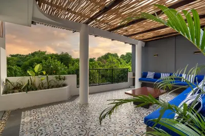 an outdoor patio with blue furniture and plants at Jimbaran Breeze Villa By Island Escape in Jimbaran