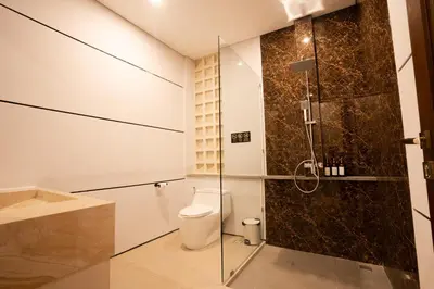 a bathroom with a toilet and a glass shower at NEW! 3BR HnRR Villa Near Seminyak in Kerobokan