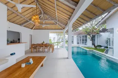 an open living room with a swimming pool and a dining room at Villa Cocodrilos 1 by Pertama Management in Seminyak