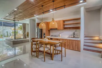 a kitchen with a wooden table and chairs at The Coral Villa 3 BR Brand New Villa in Umalas in Kerobokan
