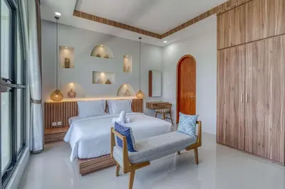 a bedroom with a large white bed and a chair at The Coral Villa 3 BR Brand New Villa in Umalas in Kerobokan