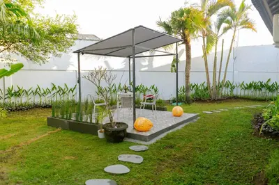 a garden with a pavilion with a chair and pumpkins at Peaceful 2br with pool & garden in Seminyak