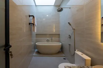 a bathroom with a tub and a sink and a toilet at Sandat Villa 123 in Canggu