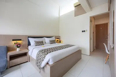 a bedroom with a large bed and a bathroom at Bali True Living in Denpasar