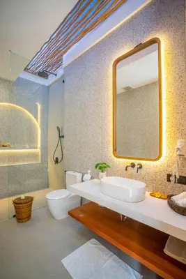 a bathroom with a sink and a toilet and a mirror at Zahra Villas in Nusa Dua