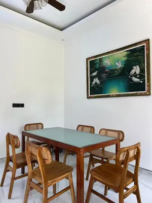 a dining room table with chairs and a painting on the wall at Modern 3BR Villa with Private Pool & Rooftop in Nusa Dua in Nusa Dua