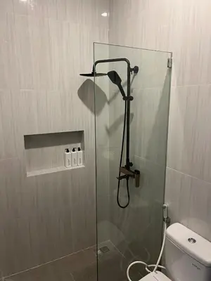 a bathroom with a glass shower with a toilet at Modern 3BR Villa with Private Pool & Rooftop in Nusa Dua in Nusa Dua