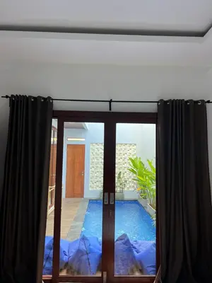 a window with a view of a swimming pool at Modern 3BR Villa with Private Pool & Rooftop in Nusa Dua in Nusa Dua