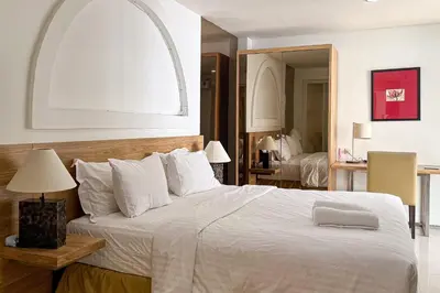 a bedroom with a large white bed with a window at Green Leaf Villa - 1 Bedroom pool Villa with Minimum Stay 2 Nights in Nusa Dua