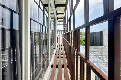 a corridor of a building with glass windows at Green Leaf Villa - 1 Bedroom pool Villa with Minimum Stay 2 Nights in Nusa Dua