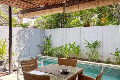 a patio with a table and chairs next to a pool at Green Leaf Villa - 1 Bedroom pool Villa with Minimum Stay 2 Nights in Nusa Dua
