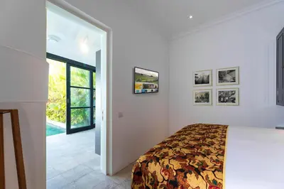 a bedroom with a bed in a white room at Abby May - Top location near Potato Head, walk everywhere! in Seminyak