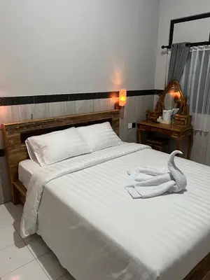 a large white bed with a towel on it at D nux House in Ngurah Rai International Airport