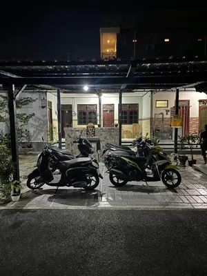 three scooters parked in front of a building at night at D nux House in Ngurah Rai International Airport