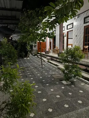 a walkway with trees and flowers in front of a building at D nux House in Ngurah Rai International Airport
