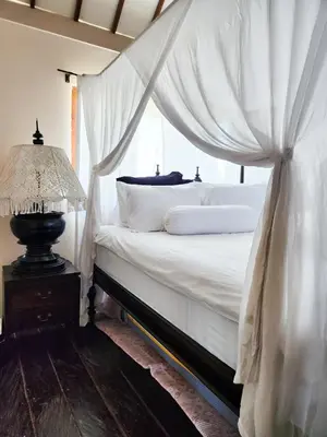 a bedroom with a white bed with a canopy at Serai House 2BR Cozy Kerobokan Home in Kerobokan