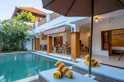 a villa with a swimming pool and a house at Genta- Petitenget 2BR villa, walk to beach! in Seminyak
