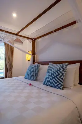 a bedroom with a bed with blue and white pillows at Genta- Petitenget 2BR villa, walk to beach! in Seminyak