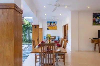 a dining room with a wooden table and chairs at Genta- Petitenget 2BR villa, walk to beach! in Seminyak