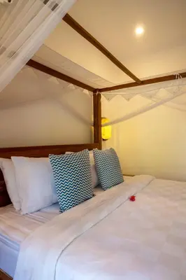 a bed with blue and white pillows in a room at Genta- Petitenget 2BR villa, walk to beach! in Seminyak