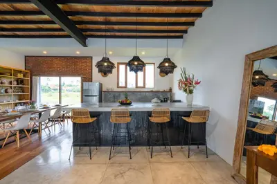 an open kitchen with a large island with bar stools at Villa Java by DreamAwayBali in Seminyak