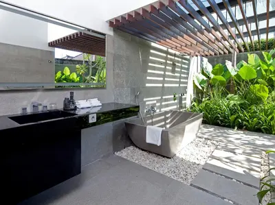 a bathroom with a large tub and a sink at Villa Issi in Seminyak