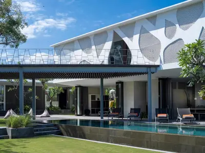 a house with a balcony and a swimming pool at Villa Issi in Seminyak