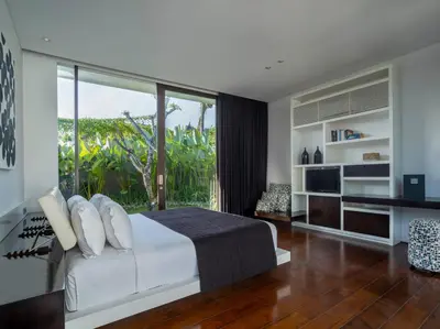 a bedroom with a white bed and a large window at Villa Issi in Seminyak