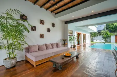 a living room with a couch and a table and a pool at Villa Nuga By DreamAwayBali in Seminyak