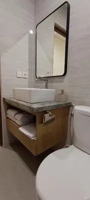 a bathroom with a sink and a toilet and a mirror at Kubunaku Sanur Bali in Sanur